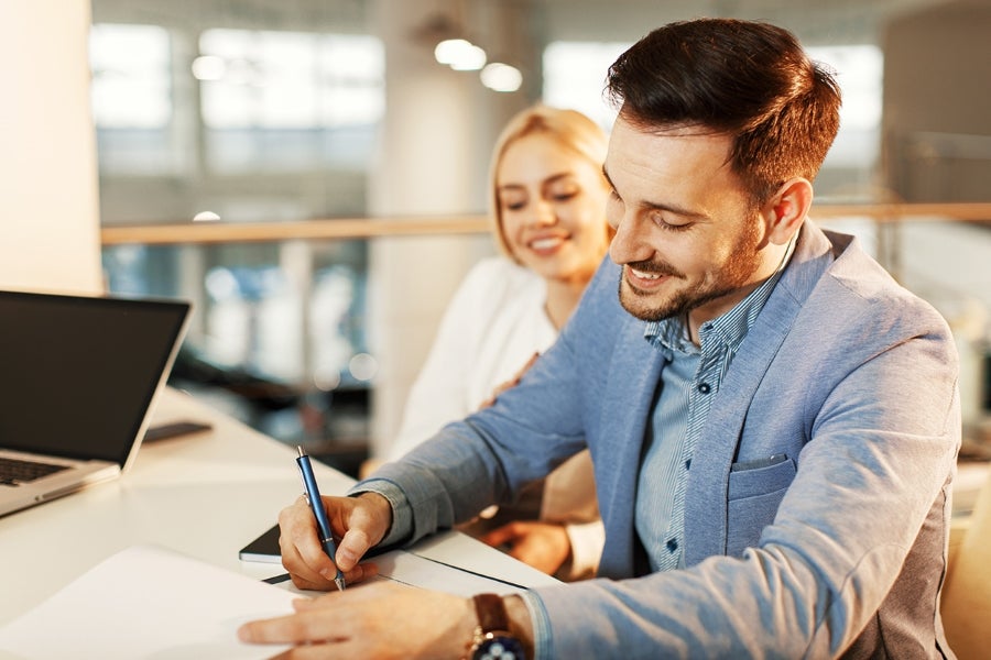 Customer Signing Vehicle Purchase or Financing Documents at a Dealership Desk